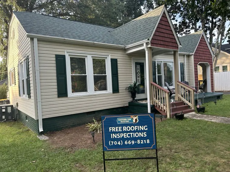 Completed roof replacement on a Charlotte area home with an Eastern Oak Roofing free inspection sign in the yard
