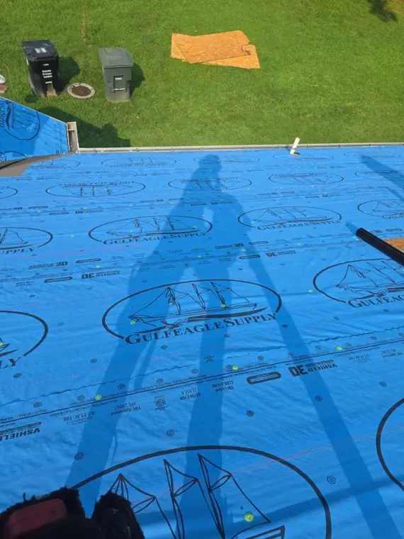 Synthetic underlayment installed across a roof deck before shingles go on